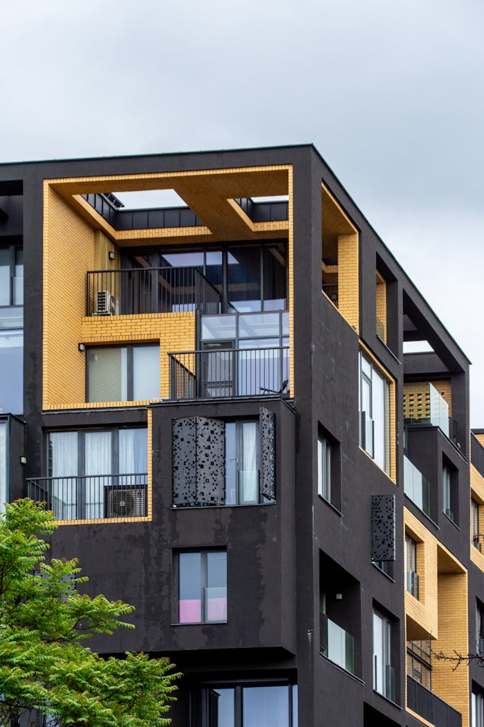 home-hero-bg Stylish modern apartment building featuring bold geometric design and contrasting colors, reflecting contemporary urban architecture.