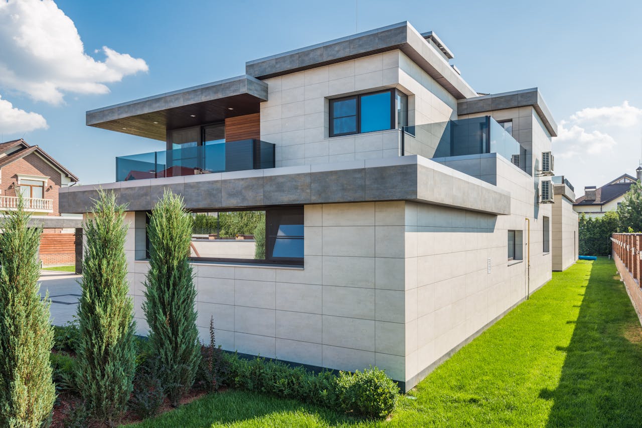 home-services-02 Contemporary two-story house with clean lines surrounded by green grass and blue sky.